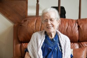 Dorothy, a Meals on Wheels recipient, smiling at her front door