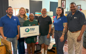 Devonne, a Meals on Wheels recipient, with a Meals on Wheels and TXU volunteer team